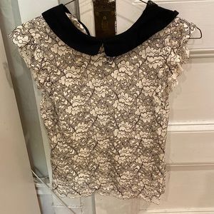 Lace sleeveless top with black collar.